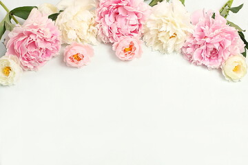 Beautiful peony flowers and roses on a light background, flower arrangement with place for text,...