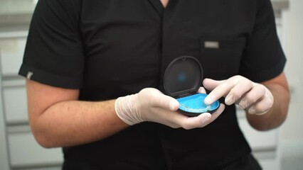 Professional dentist presenting clear aligners orthodontic treatment tool for problematic teeth in contemporary stomatology center doctor holding device closeup