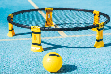 a yellow ball against the background of a "trampoline" for playing spikeball, a spikeball in a miniature analogue of volleyball outside. focus on the ball