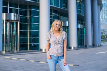 Fototapeta na wymiar Stylish beautiful blonde walks around the city, great design for any purpose. Attractive elegant woman in jeans.