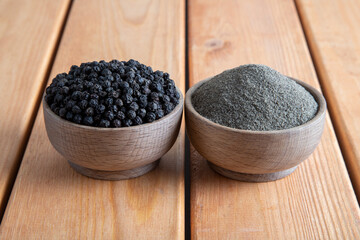 Ground black pepper with peppercorns  on a wooden table,top view