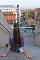 A girl looking at buildings and streets of Barcelona from top of a hill, Catalonia, Spain