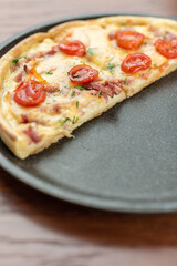 Pizza on a wooden table. Empty place. Half a pizza in a dark frying pan.