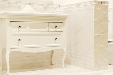 Bathroom cabinet. dressing table in classic white style. interior is lined with beige tiles