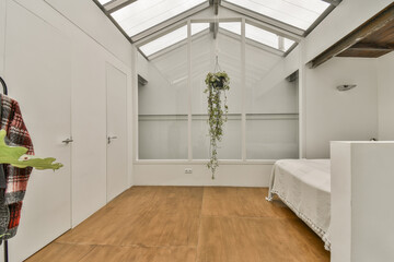 the inside of a room with wood flooring and white walls, including a skylight that has been...
