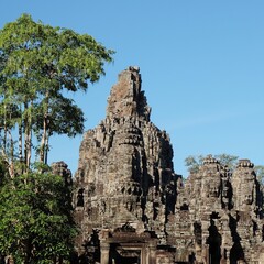 Fototapeta na wymiar The architecture-rich Bayon Temple in Cambodia, showcased on a sunny, warm day.