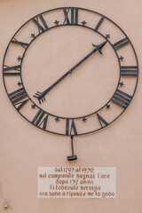 The ancient clock of the bell tower of Caslano, Switzerland, attached to the wall of a building in...