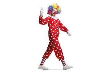 Full length shot of a clown in red costume walking and waving