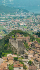 Fototapeta na wymiar Aerial view of the medieval walls and castle of Tenno overlooking Riva del Garda. Mountains and hills around Garda lake. Trentino, Italy