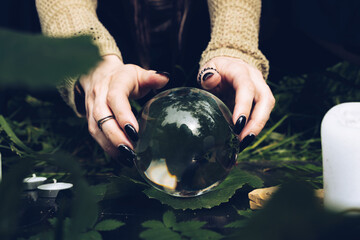close up hands holding fortune-telling ball on a grass in the forest