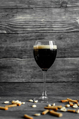 dark beer in a transparent glass on a gray background. a cooling summer drink.