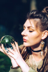 Naklejka premium Portrait of a girl who holds a fortune-telling ball in her hands