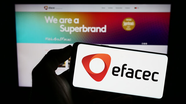 Stuttgart, Germany - 06-24-2023: Person holding mobile phone with logo of energy company EFACEC Power Solutions SGPS S.A. on screen in front of web page. Focus on phone display.