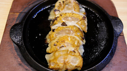 Yaki Tori Ebi Iri Gyoza is a dish with crispy and juicy gyoza, filled with a mouth-watering prawn, garlic and ginger filling and served with a soy and chili gyoza dipping sauce serve in a hot plate.
