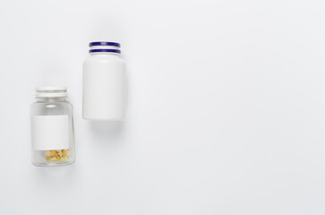 Plastic bottles with vitamins on white background, top view