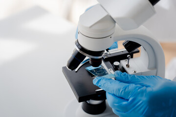 Doctor or research scientist looking under microscope analyzing test sample in laboratory biotechnology specialist ambitious young people Works with advanced devices