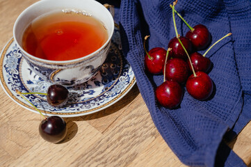A handful of cherries on a blue napkin near the cup. Sweet red cherries. Cherries. fruit still life. top view