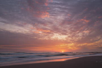 Fototapeta na wymiar wschód słońca na bałtyku z podświetlonymi chmurami