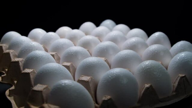 Close-up Eggs in paper tray rotation isolated on black background. Fresh eggs in an egg kiosk. The egg tray or egg tray is spinning. 