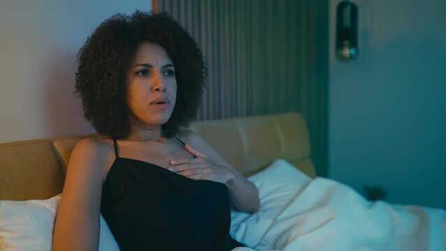 Young woman feeling chest pain at night, having problems with heart, disorder