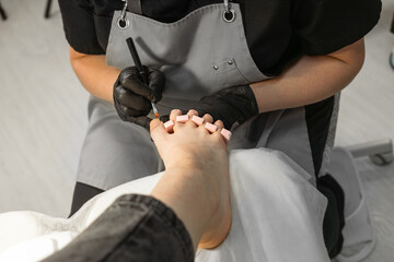 Application of gel nail polish, aesthetic pedicure procedure,