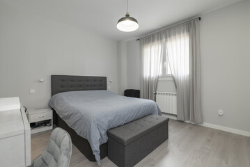 a double bedroom with a bed with a gray bedspread,