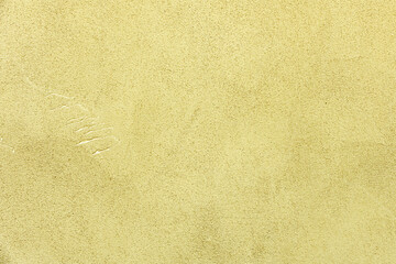 A very textured wall painted light yellow