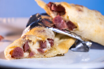 Bread stuffed with salami and cheese. High calorie homemade food.metal