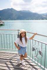 Stylish little girl walking trough the bridge and look at the lake. Adorable girl 