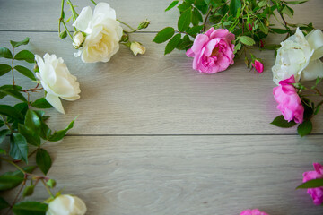 Floral background of pink and white roses on a light wooden