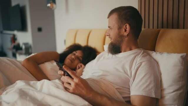 Young husband hiding secrets from his wife, using dating application, cheating