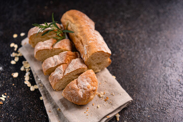 Sliced baguette bread on wooden coaster and rustic background. Artisan Sourdough bread.