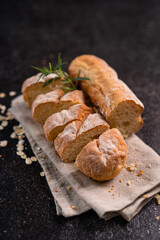 Sliced baguette bread on wooden coaster and rustic background. Artisan Sourdough bread.
