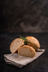 Homemade whole grain brown buns with sesame seeds on rustic background. Healthy artisan bread.