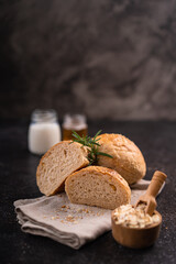 Homemade whole grain brown buns with sesame seeds on rustic background. Healthy artisan bread.