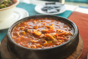 Shrimps in casserole, cooked with pepper and tomatoes in close up image
