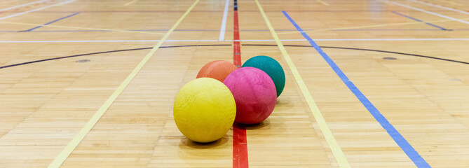 groupe de ballons colorés en caoutchouc sur le sol en bois d'un gymnase intérieur