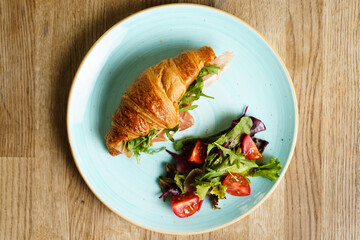 Top down view of Croissant with ham, vegetables and cheese
