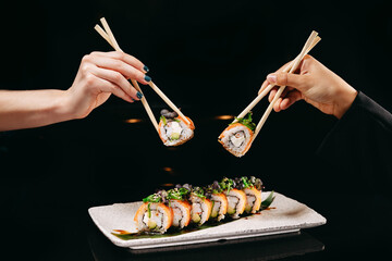 Chuka Roll in Chinese chopsticks in hands over the dish