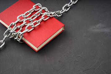red book bound by a steel chain on a gray background