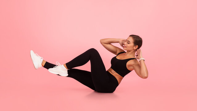 Fitness Workout. Young Woman Doing Bicycle Crunch Abs Exercise Over Pink Background