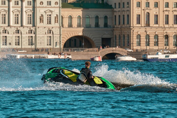 A man rides a jet ski on the river. A male performs various tricks on a aquabike.