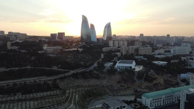 Baku, Azerbaijan - June 27, 2023: Aerial drone footage of the iconic Flame Towers during a breathtaking sunset, showcasing the impressive skyline of Baku