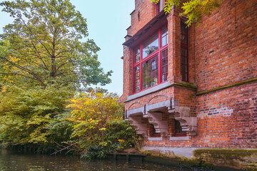 Bruges, Belgium. Historic center of the city. Glazed balcony and brick wall of medieval house on Rozenhoedkaai canal. West Flanders Province, Belgium. Cityscape of Bruges (Brugge).