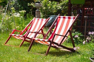 Striped lawn lounge chairs in the garden, looking forward to a vacation from work        