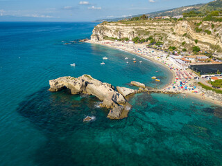 Italy, July 2023: aerial view from drone of caribbean sea and beach with tourists and umbrellas at Baia di Riaci near Tropea in Calabria
