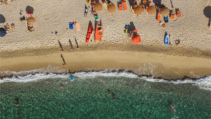 Italy, July 2023: aerial view from drone of caribbean sea and beach with tourists and umbrellas at Baia di Riaci near Tropea in Calabria