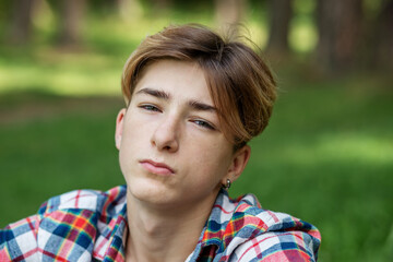 Close-up portrait of teenager boy outdoors. Gen Z. Identity development. Unhappy and stress.