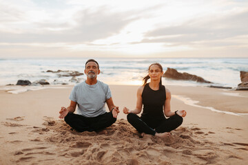 Fototapeta premium Serious senior caucasian lady and man in sportswear practice yoga and breathing exercises with closed eyes
