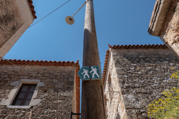 Walker street sign in an old traditional village with stone houses, in Mani, Laconia, Greece.